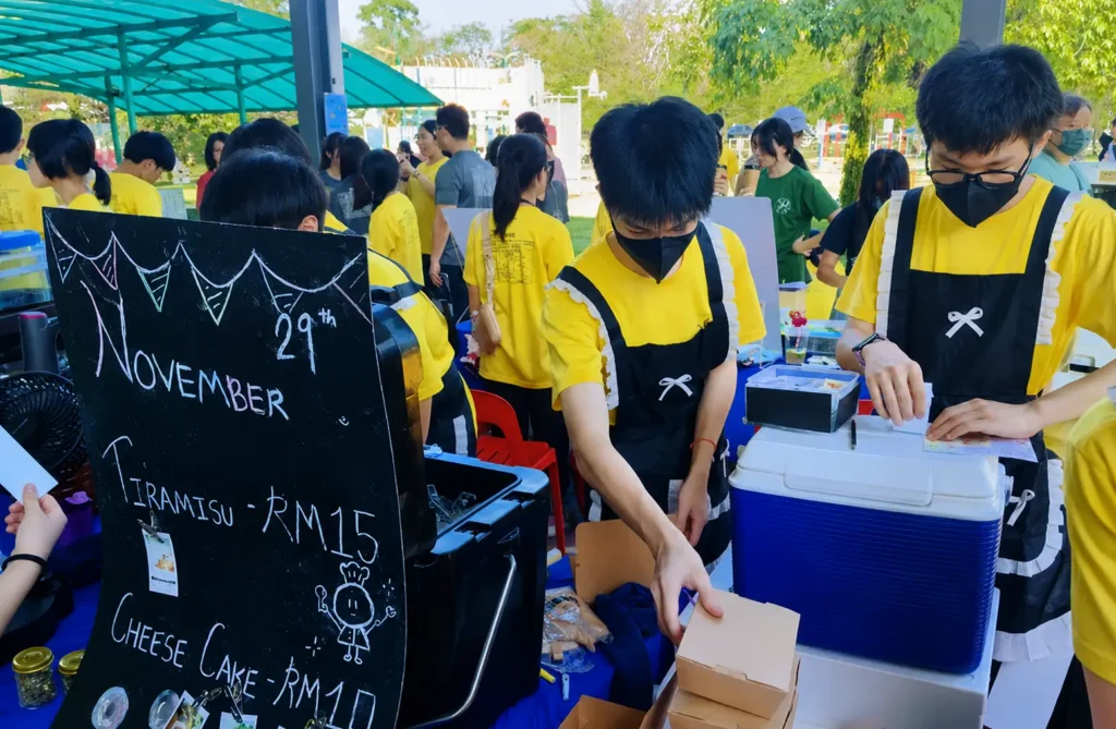 Students in aprons running a food stall at Axcel Entrepreneur Day