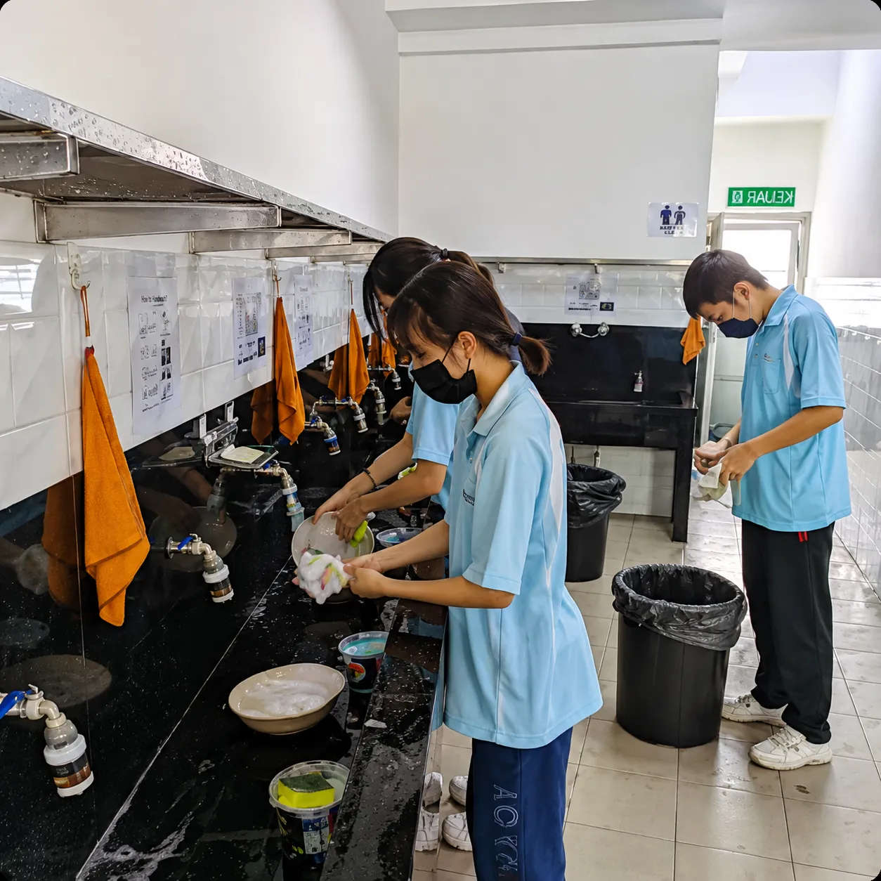 Secondary students washing up in the school kitchen
