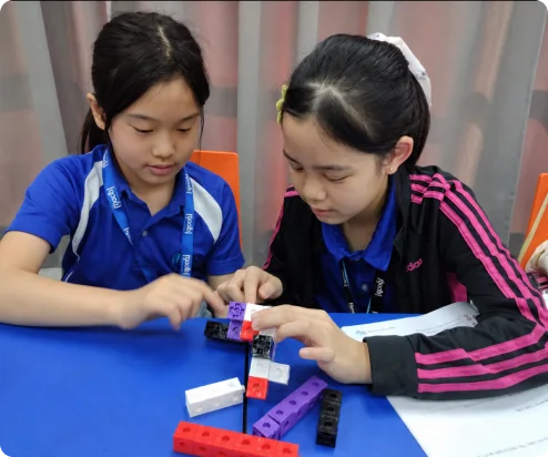 Primary students building with interlocking cubes in class