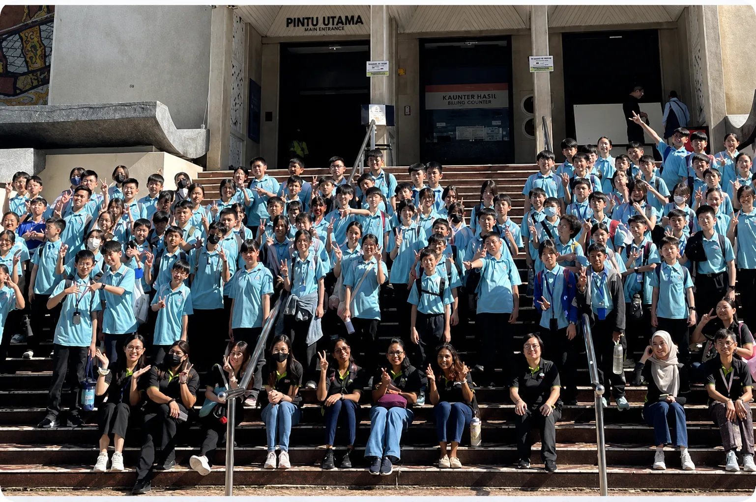 Secondary students posing for a group photo on the school steps