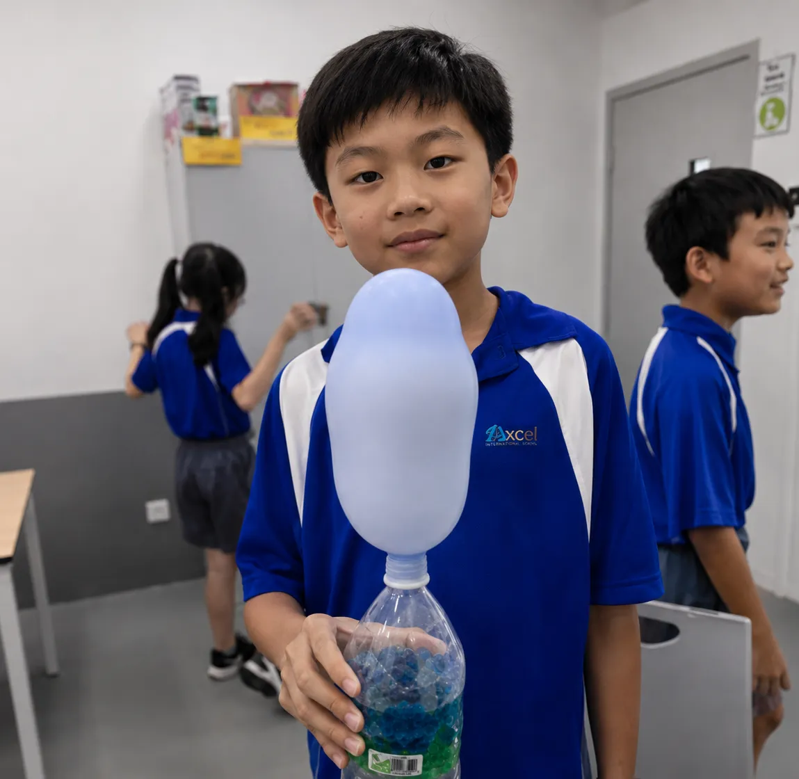 Primary student holding a balloon-and-bottle science experiment