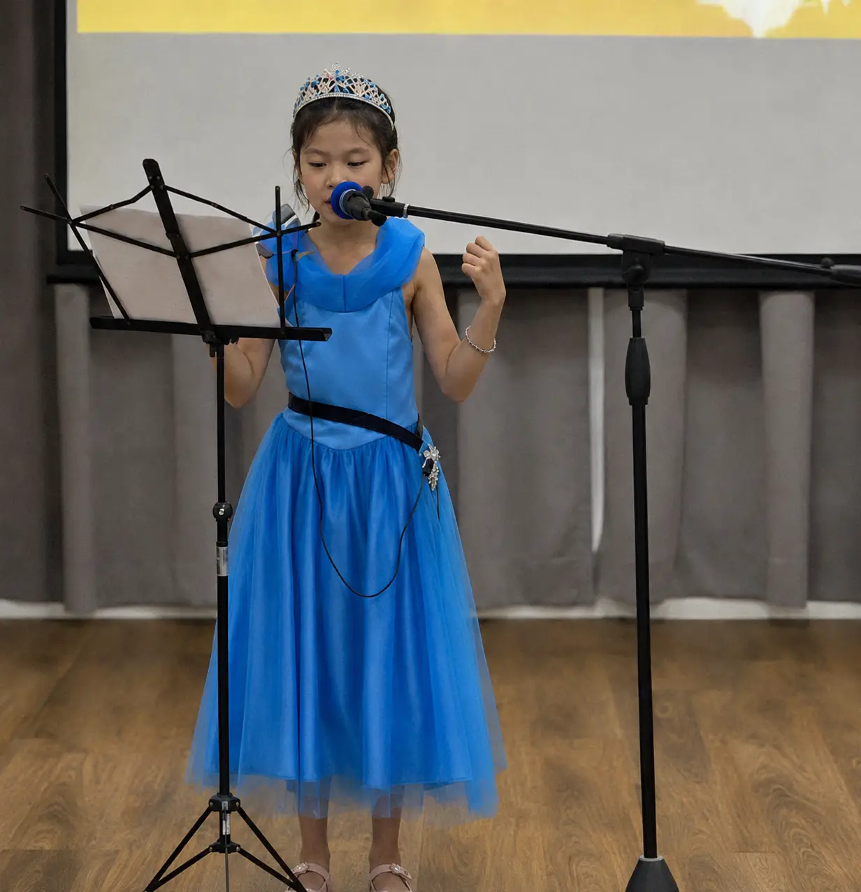 Primary student speaking into a microphone on stage