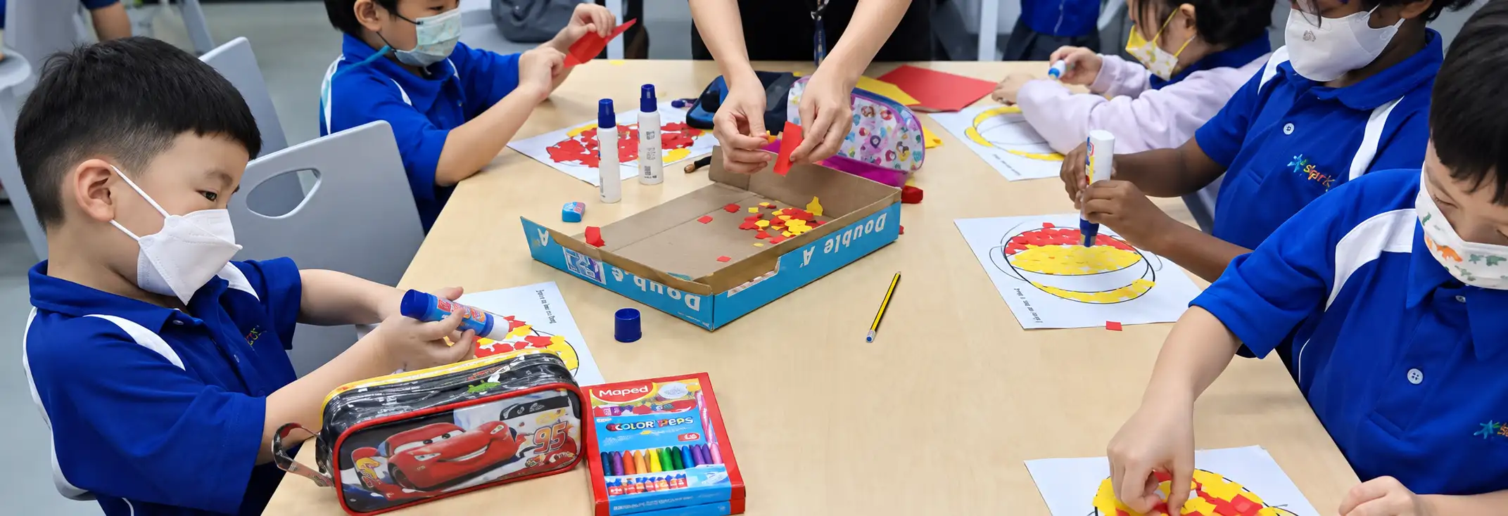 Primary students working on a hands-on activity at a classroom table