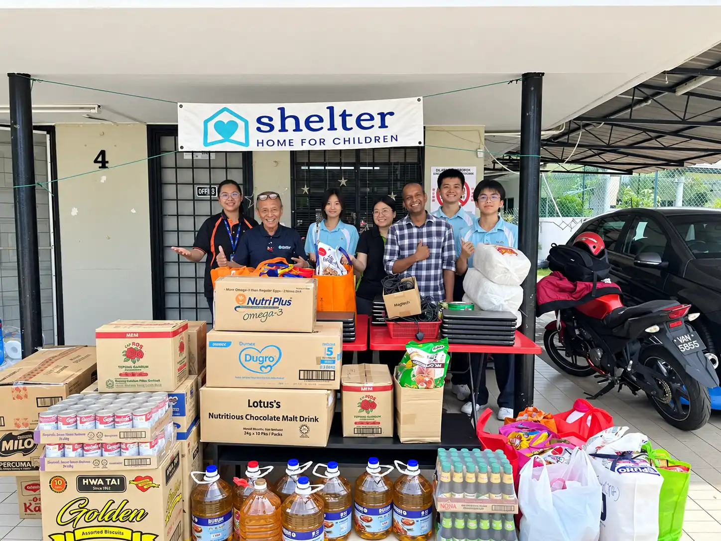 Students delivering donated food and supplies to a shelter home for children